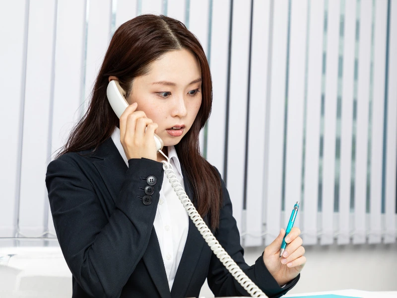 カスハラの電話対応に備え、固定電話で応対する女性社員