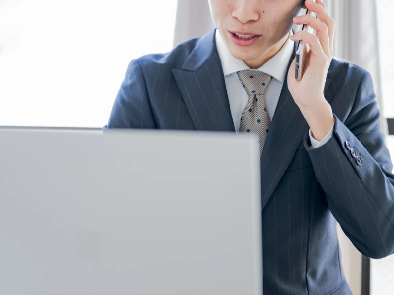 Male employee handling customer harassment over the phone at his laptop